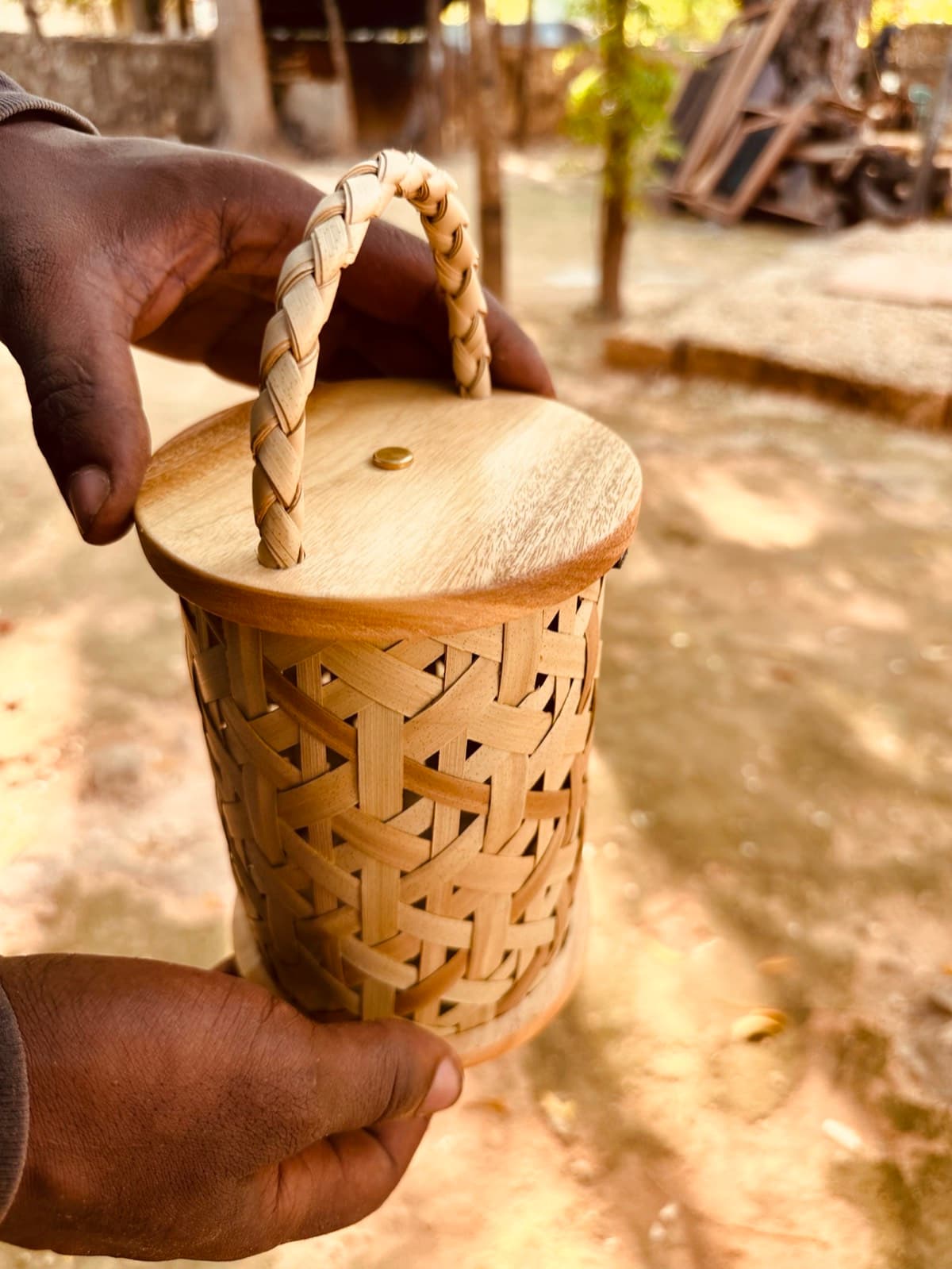 Finished Shadow Lantern with lid held outdoors in warm afternoon light